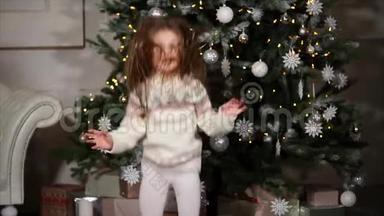 可爱的小女孩在圣诞树附近快乐地跳跃。